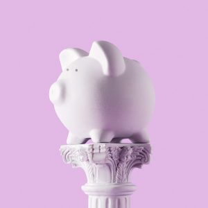 Piggy bank on antique column. Concept of money savings investments and art.